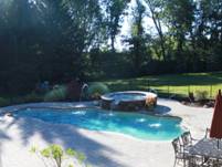 Image of an In-ground Fiberglass Pool with a Spill-Over Spa Finished with the Pebble Beach Finish